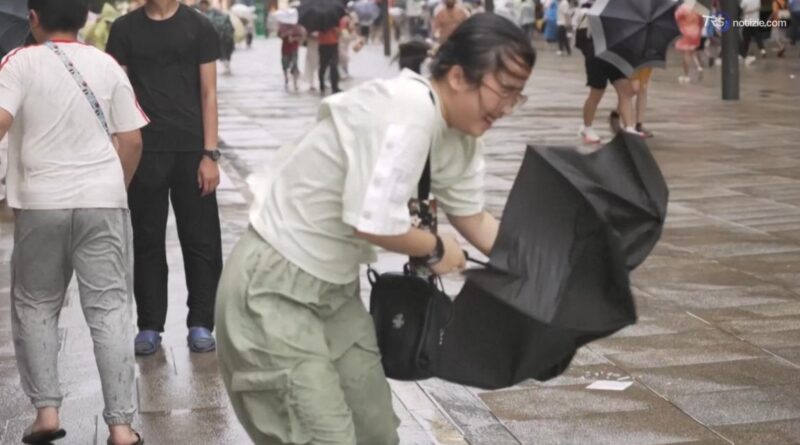 I forti venti del tifone Dolphin ribaltano gli ombrelli e sferzano residenti e turisti a Shanghai