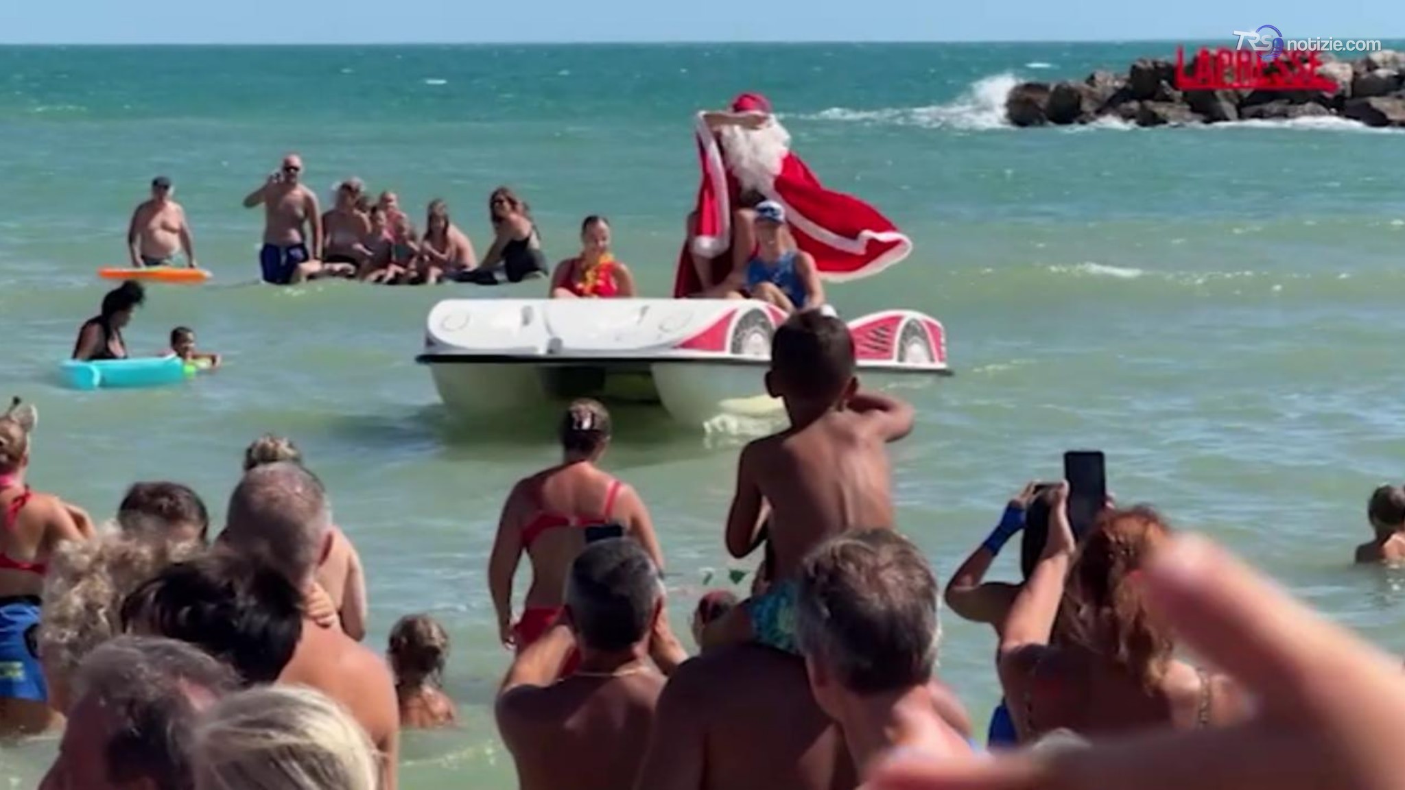 Babbo Natale tra i bagnanti a 38 gradi arriva in pedalò: la curiosa iniziativa