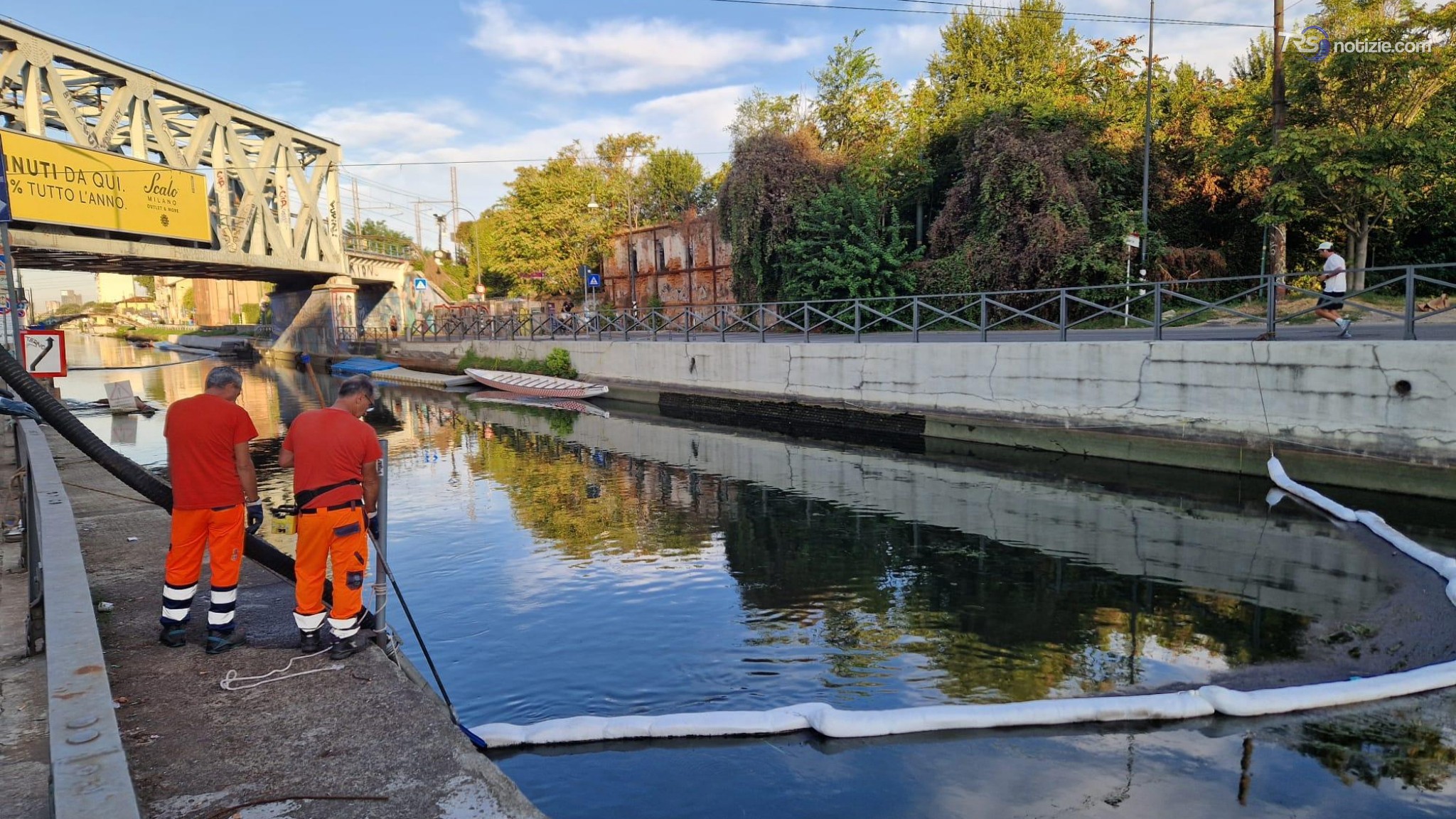 Chiazza di gasolio sul Naviglio, i vigili del fuoco la spingono per compattarla e raccoglierla