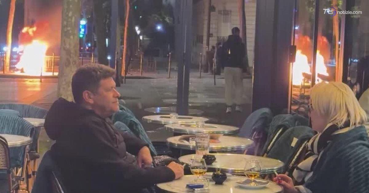 Parigi, l’aperitivo surreale: la coppia continua a bere mentre infuriano gli scontri