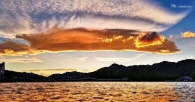 Il tramonto infiamma il cielo dello Yunnan: nuvole rosse e riflessi d'oro sul lago